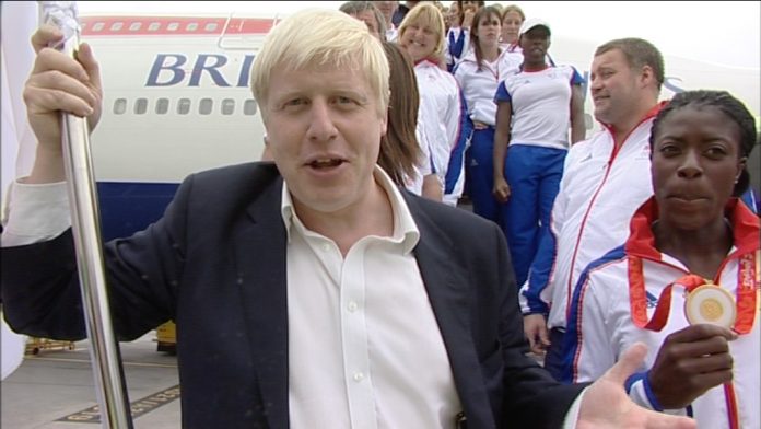 Boris Johnson at Heathrow with Olympic flag